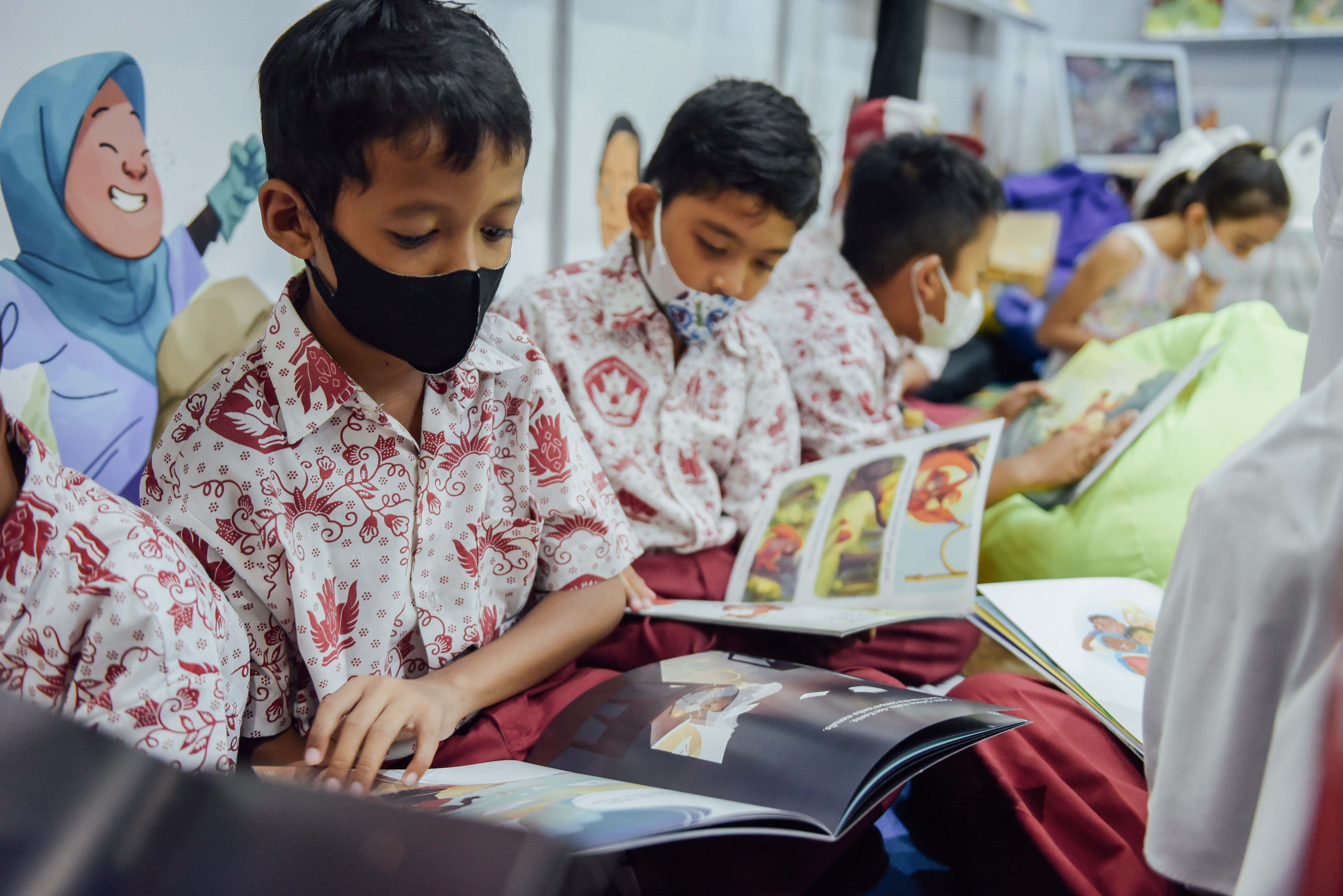 A group of Indonesian boys sit together reading the books from Ashoka Indonesia's "Becoming a Changemaker" series