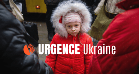 The photo shows a little kid in a red jacket looking straight into the camera. There is also a white sign on the photo which says "Urgence Ukraine" and the logo of Bibliothèques Sans Frontières.