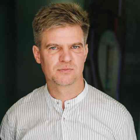 Paul Radu, a white man with blonde hair in a white shirt