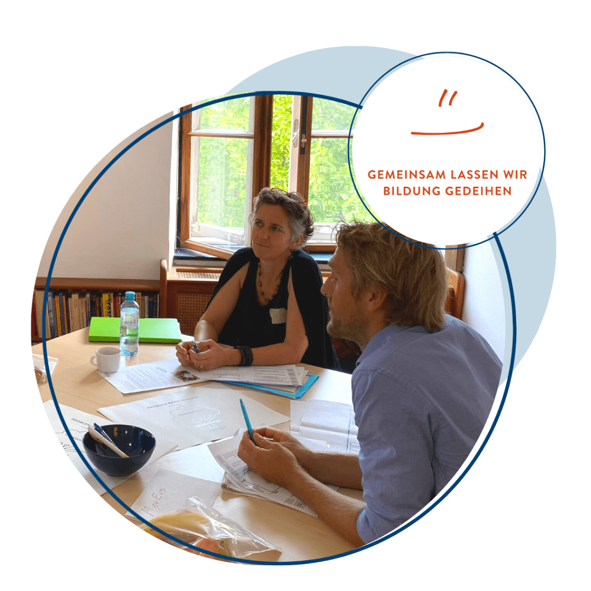 photo of man and woman sitting at a workshop table 