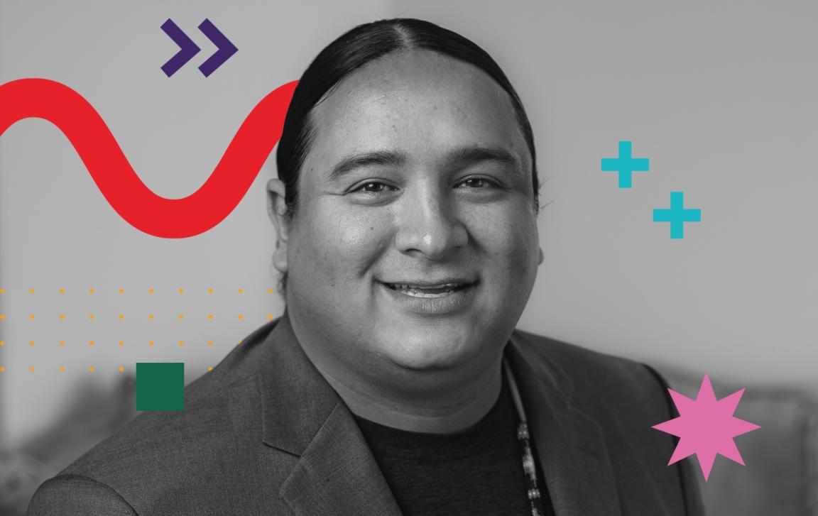 It is a black and white photo featuring an Indigenous man, wearing a t-shirt under a jacket. There are some graphic elements around him, as a red zigzag curved-line, two purple arrows, two blue plus sign, a small green square and a pink eight-pointed star.