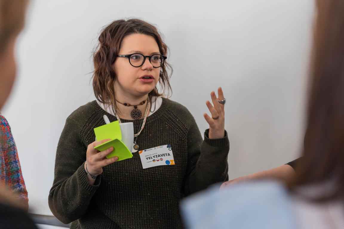 A girl holding post-its in one hand and talking