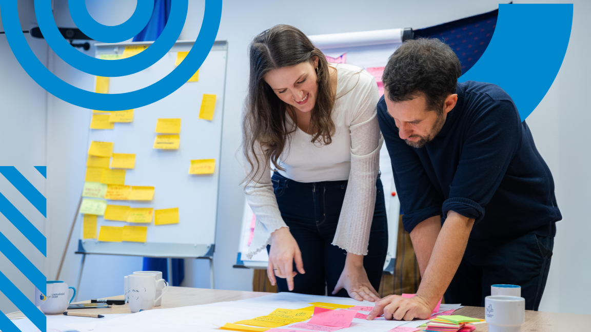 Young woman and man looking at post-its on the desk