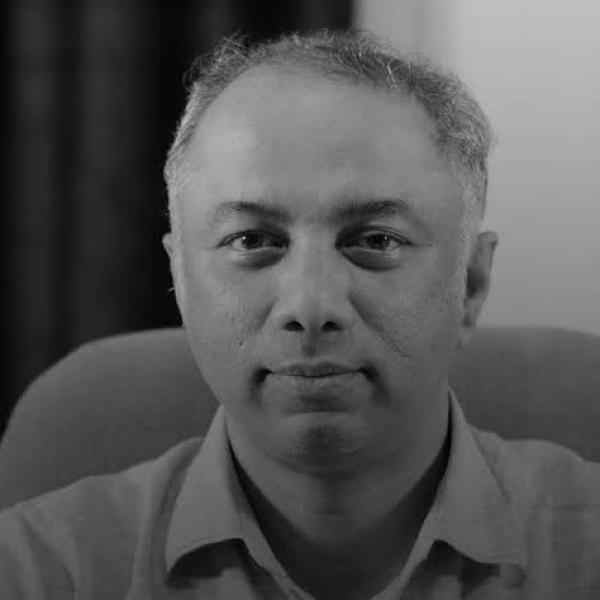 Headshot of Ashoka Fellow Harish Hande. Black and white photo. Person with short hair smiling at the camera