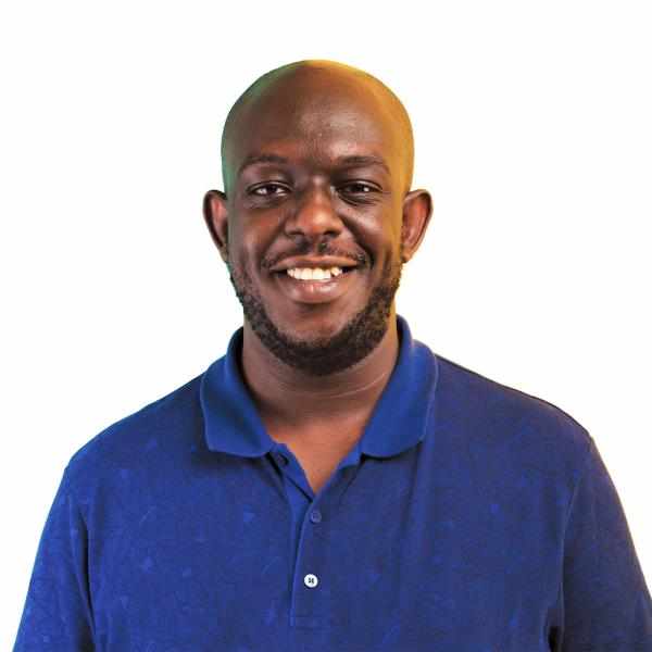 Al smiling in a blue shirt on a white background