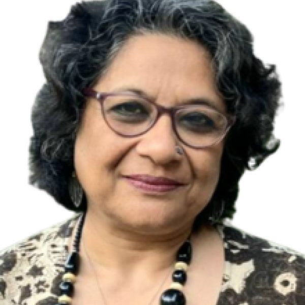 Photo of Ashoka Fellow Enakshi Gaguly of India. Person with glasses, flower blouse and necklace and short black hair smiling at the camera. Background white