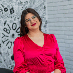 Young woman wearing glasses and red blouse, smiling