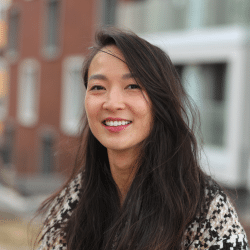 Young woman with long hair standing outside, smiling