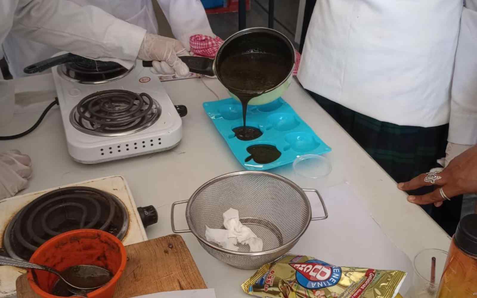 Alumnos en un laboratorio creando gomitas.