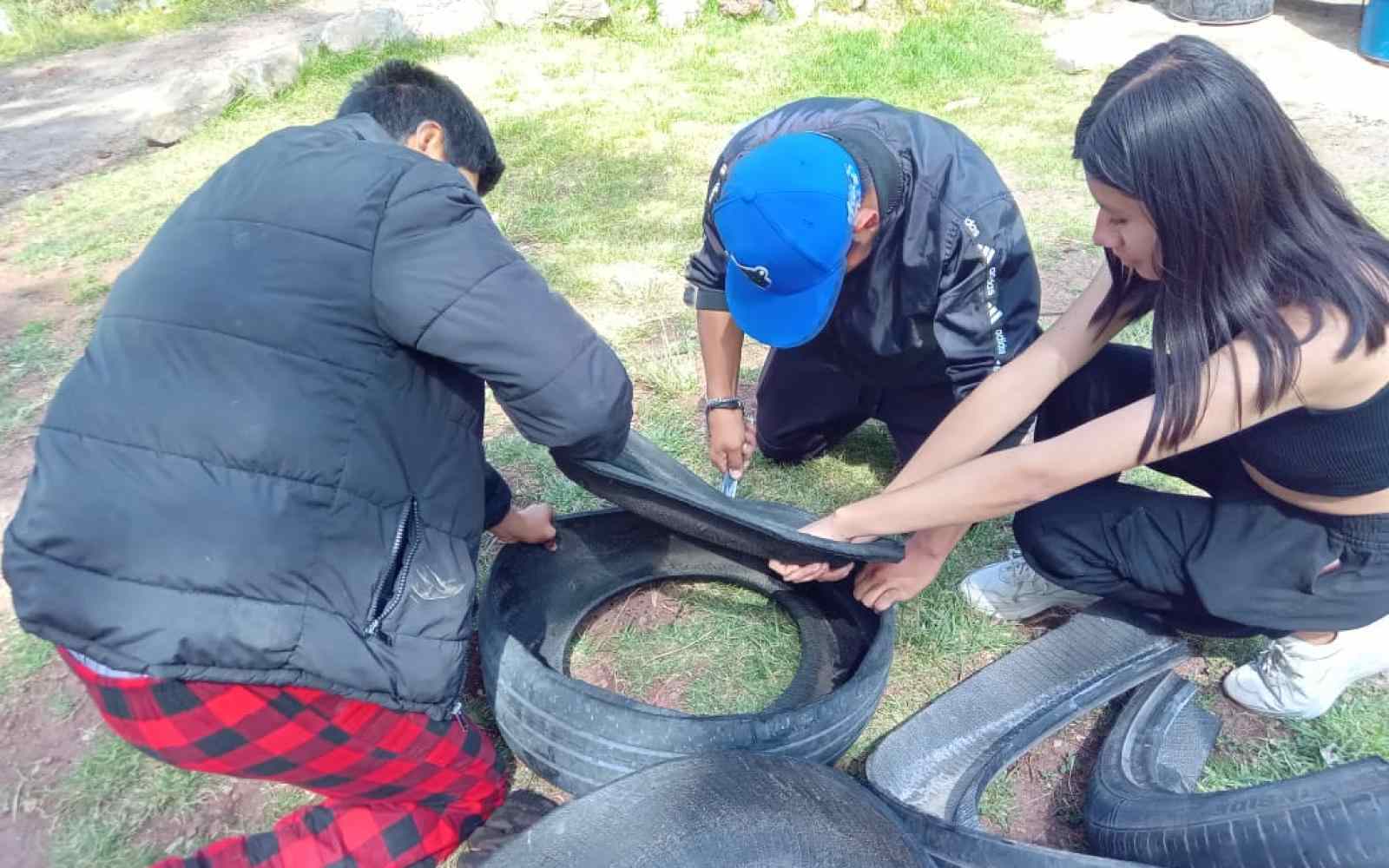 Tres jovenes cortando llantas