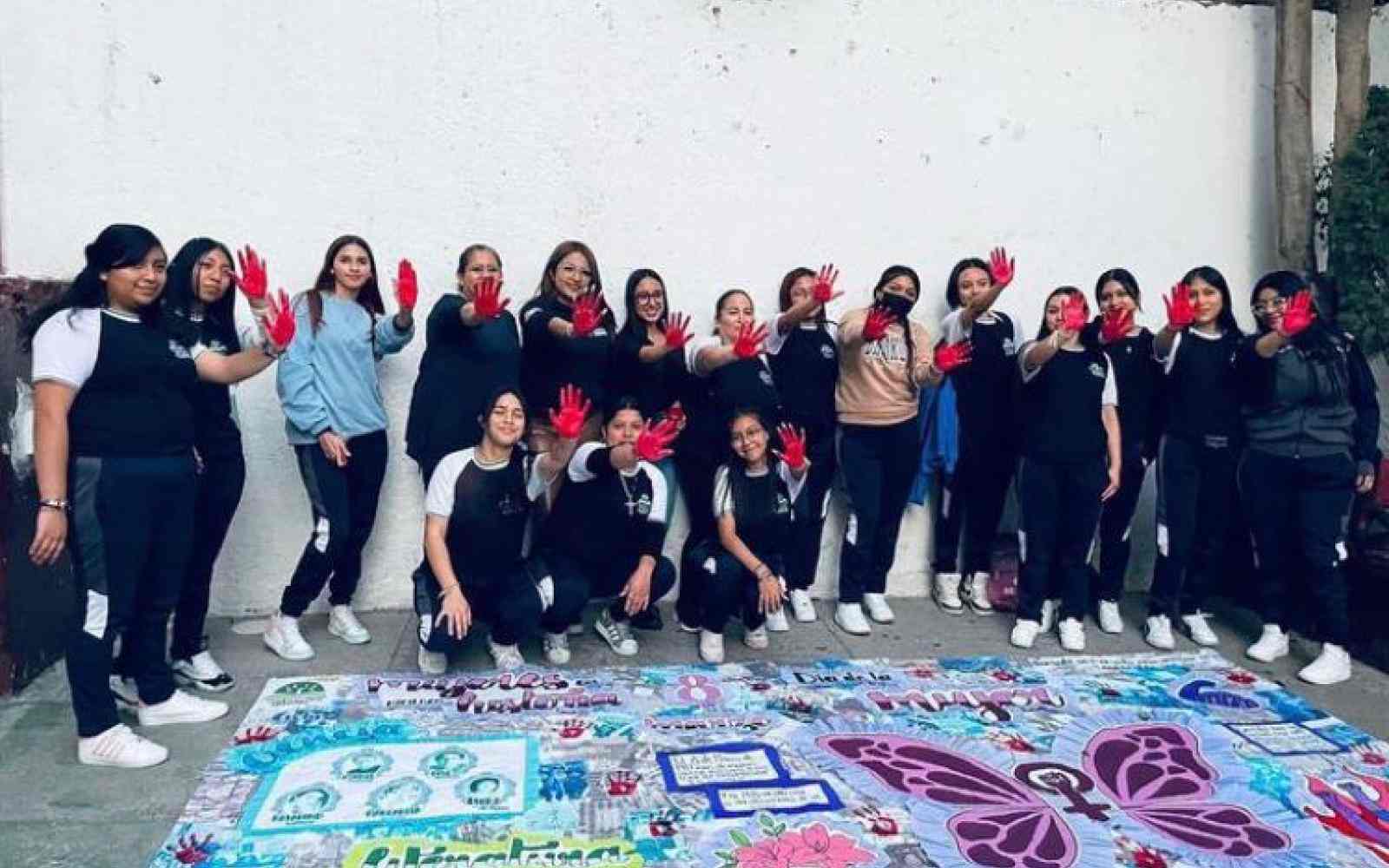 Grupo de estudiantes y maestras pintando un mural