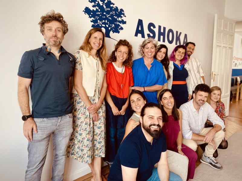 Personas que conforman el proyecto AI FOR BETTER posando bajo el logo de Ashoka