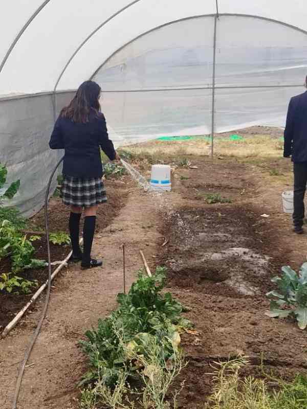 Invernadero con María regando las plantas